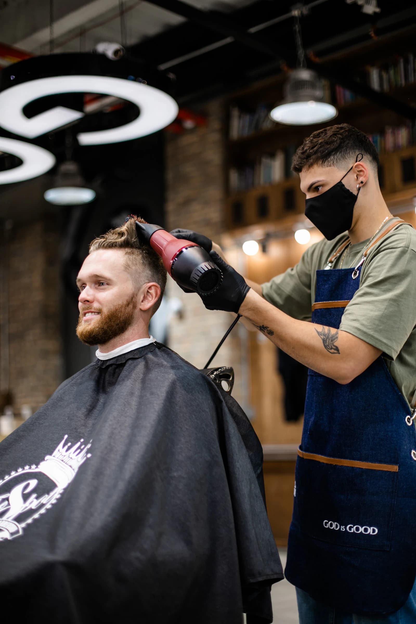 Coiffeur au travail avec un client dans son salon