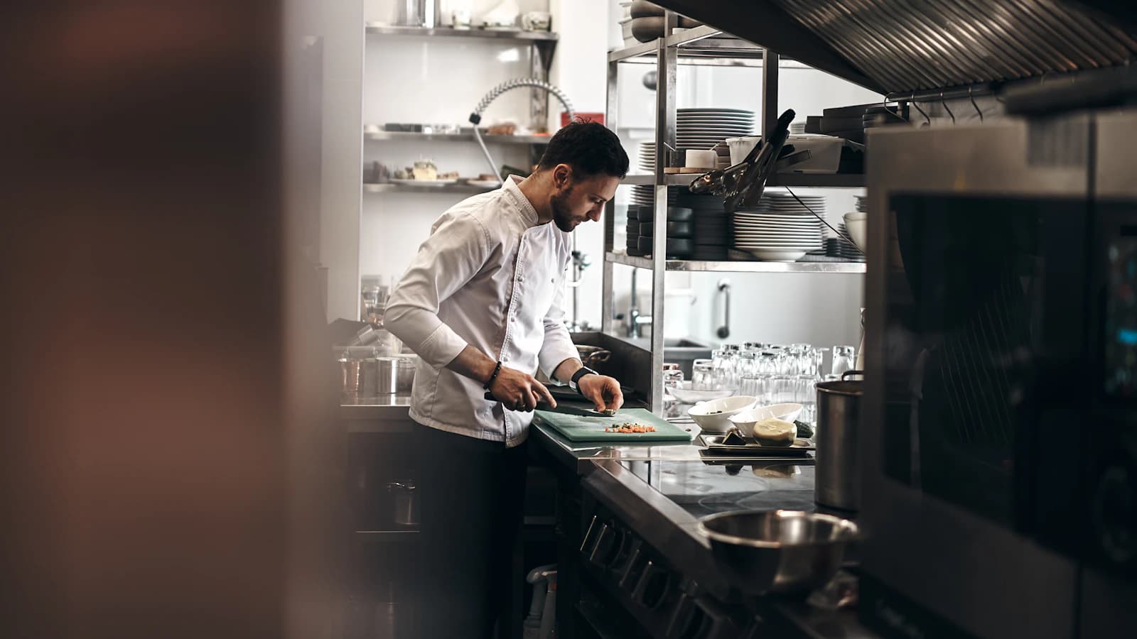 Cuisinier découpant des légumes dans une cuisine professionnelle